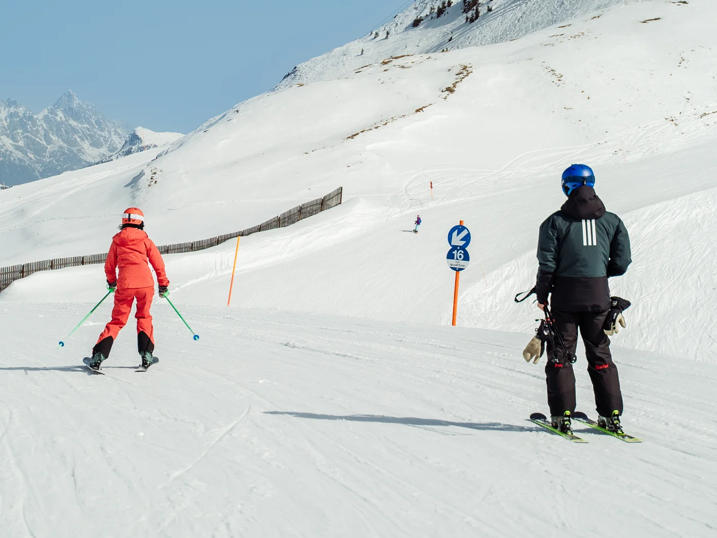 Blaue Skipiste mit Menschen die Skifahren und Kaiserwetter