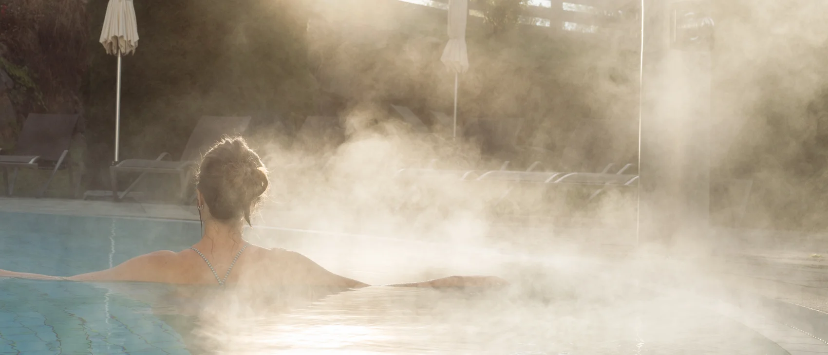Wasserdampf im außen Pool bei Sonnenaufgang