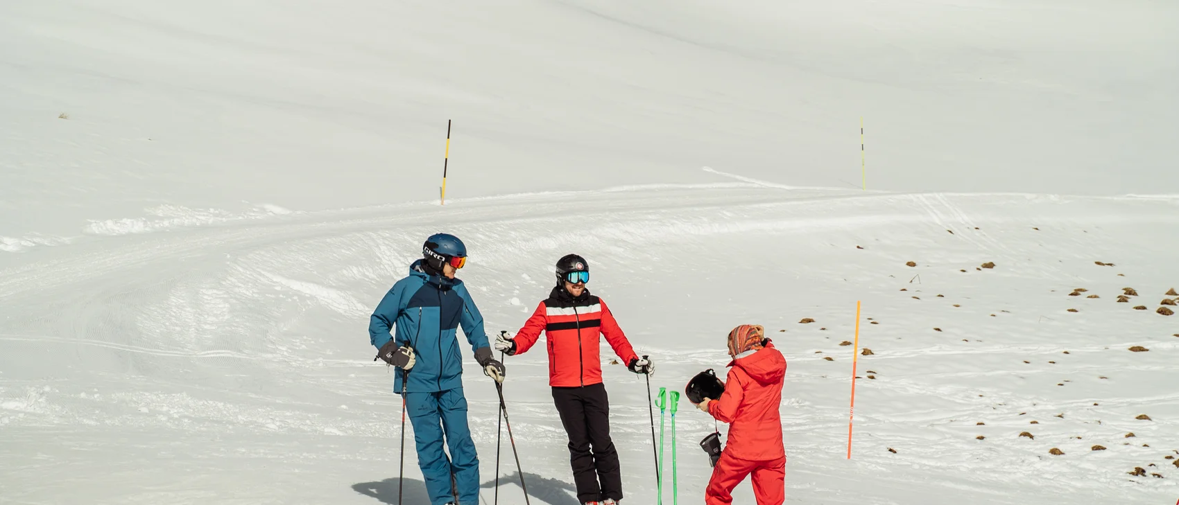 Skifahren in den Alpen bei winterlichen Bedingungen Drei Personen in Skibekleidung auf schneebedecktem Berg unter klarem Himmel