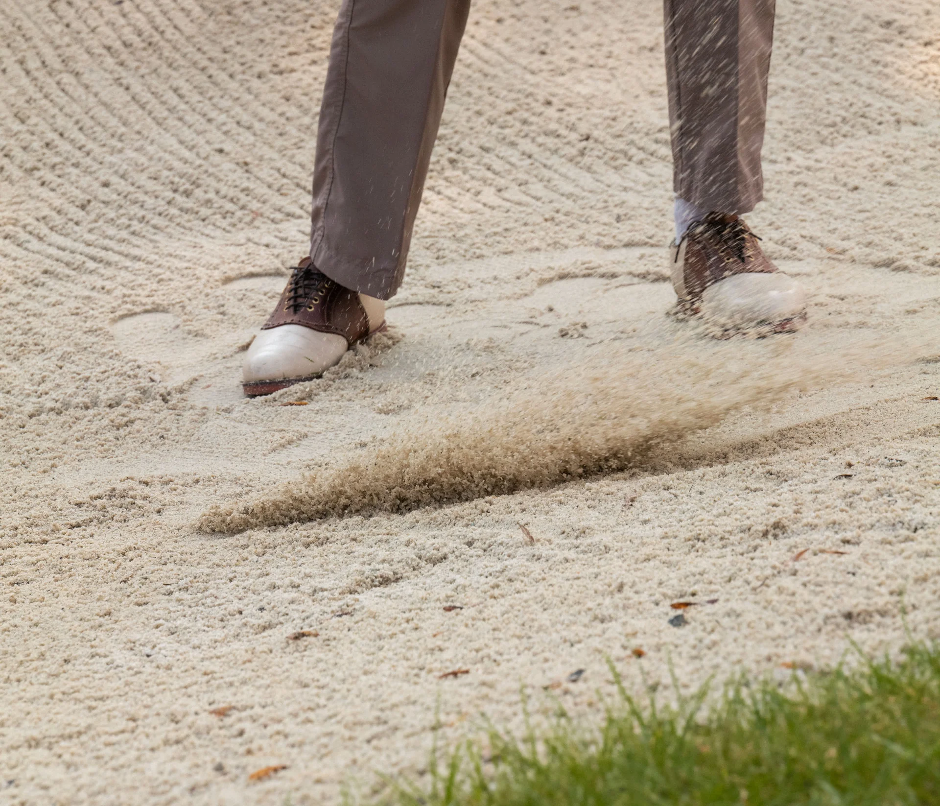 Golfer hitting ball from a sand bunker
