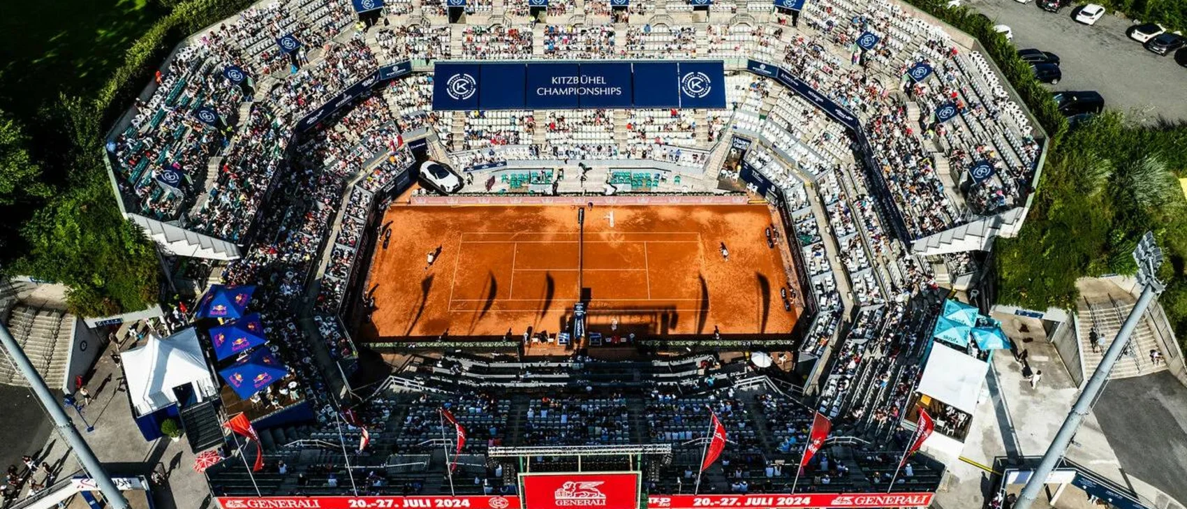 Generali Open Ladies Kitzbühel Luftaufnahme eines Tennisstadions mit rotem Sandplatz und Zuschauern bei Kitzbühel Championships