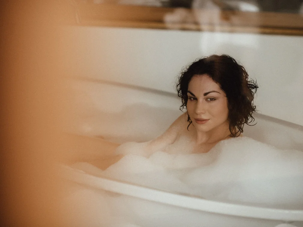 Woman relaxing in bathtub filled with bubbles