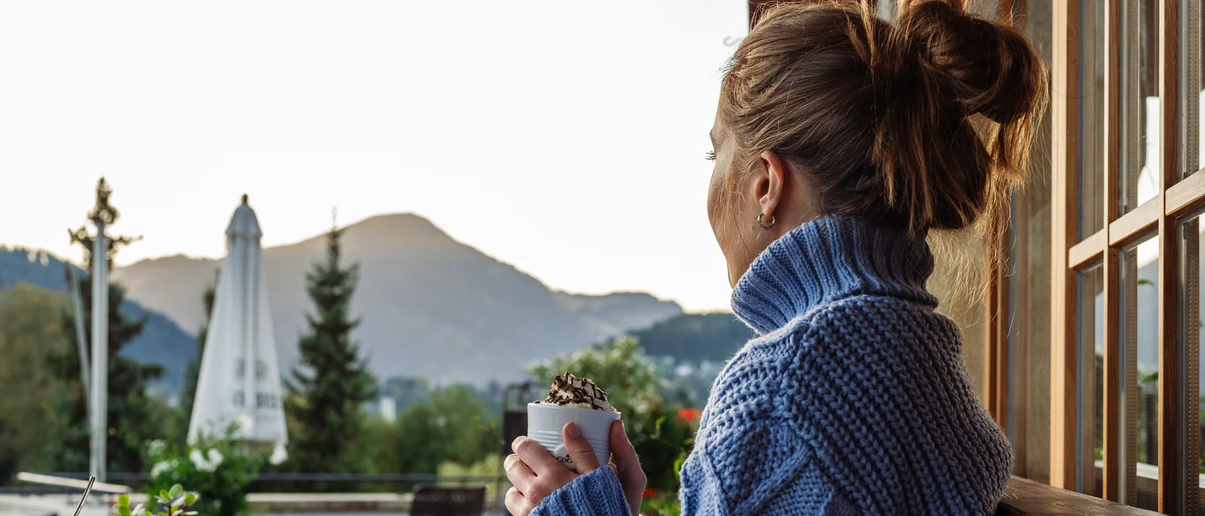 [Translate to Englisch:] Frau trinkt heiße Schokolade auf Terrasse