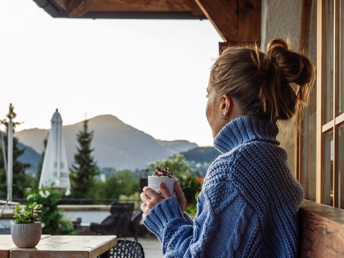 [Translate to Englisch:] Frau trinkt heiße Schokolade auf Terrasse