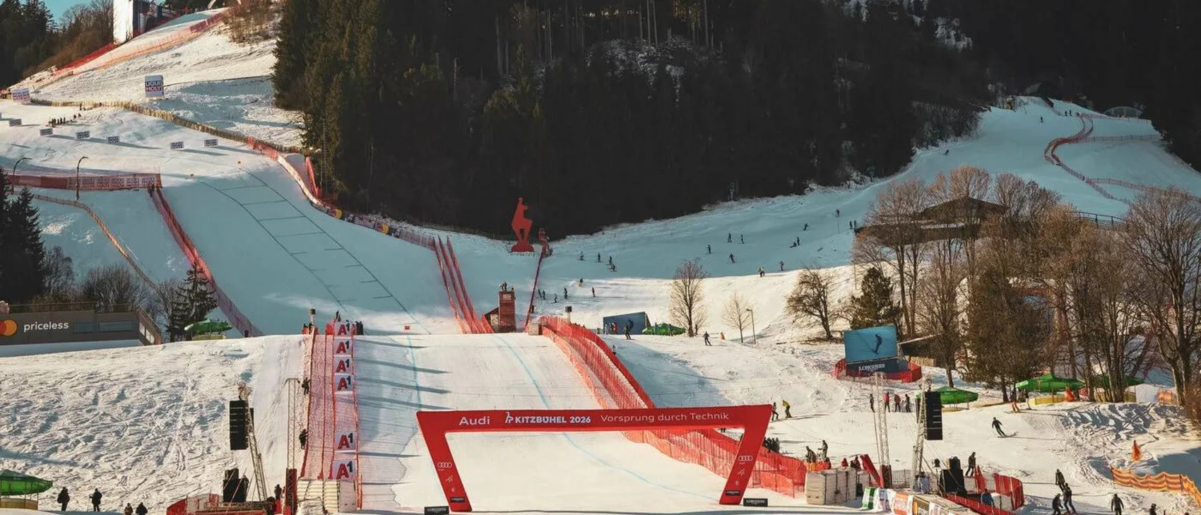 Ski jumping hill and ski area with spectators and trees in the background