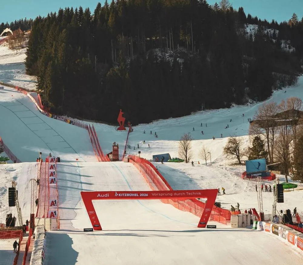 Ski jumping hill and ski area with spectators and trees in the background