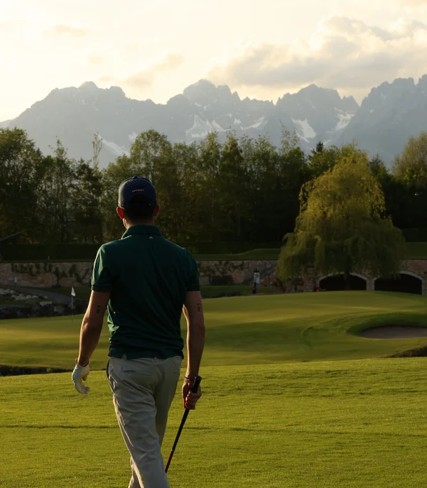 Golfer auf Golfplatz im Hintergrund der Wildekaiser