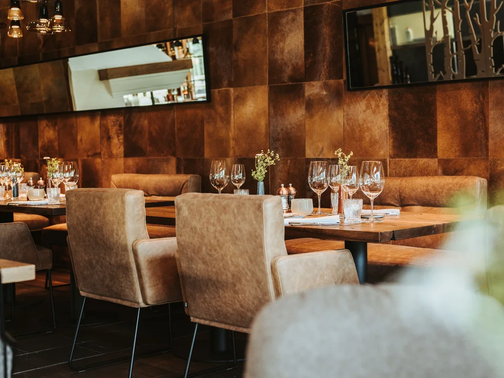 Cozy restaurant with leather chairs and set dining tables