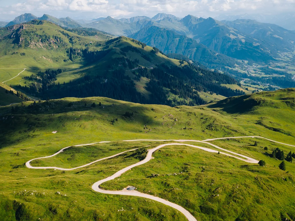 Beautiful green mountain landscape with winding roads under a blue sky