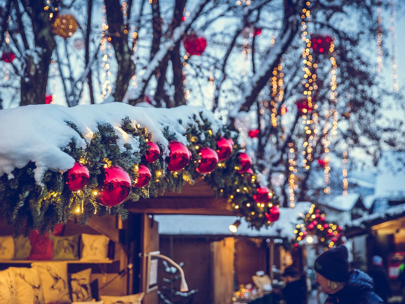 Christmas market with snowy decorations and red baubles on fir branches