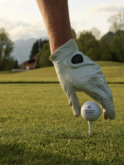 Hand greift nach Golfball
