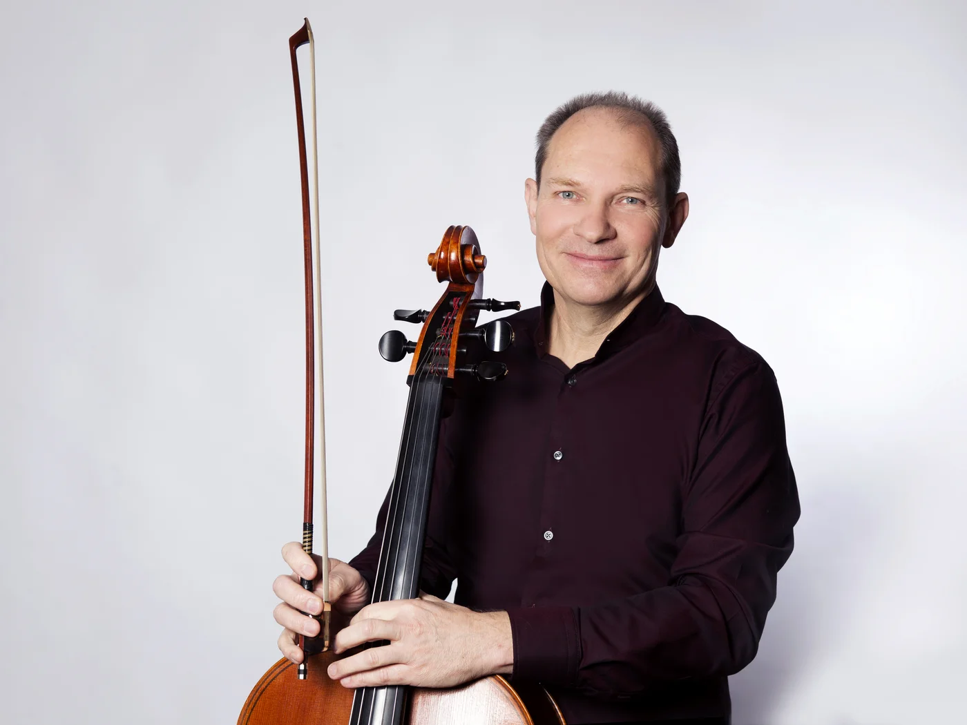 Die Schlossevents Mann mit Cello und Bogen vor hellem Hintergrund