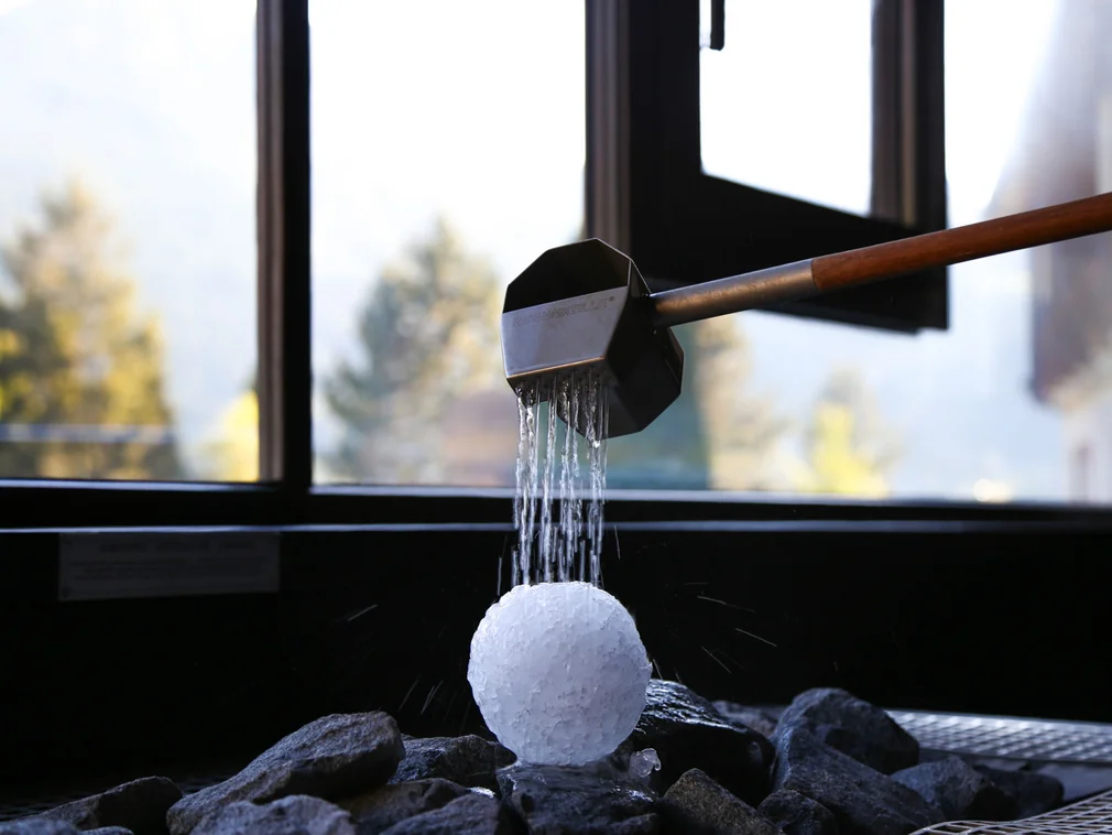 Water flowing from a strainer onto an ice ball inside a room with window