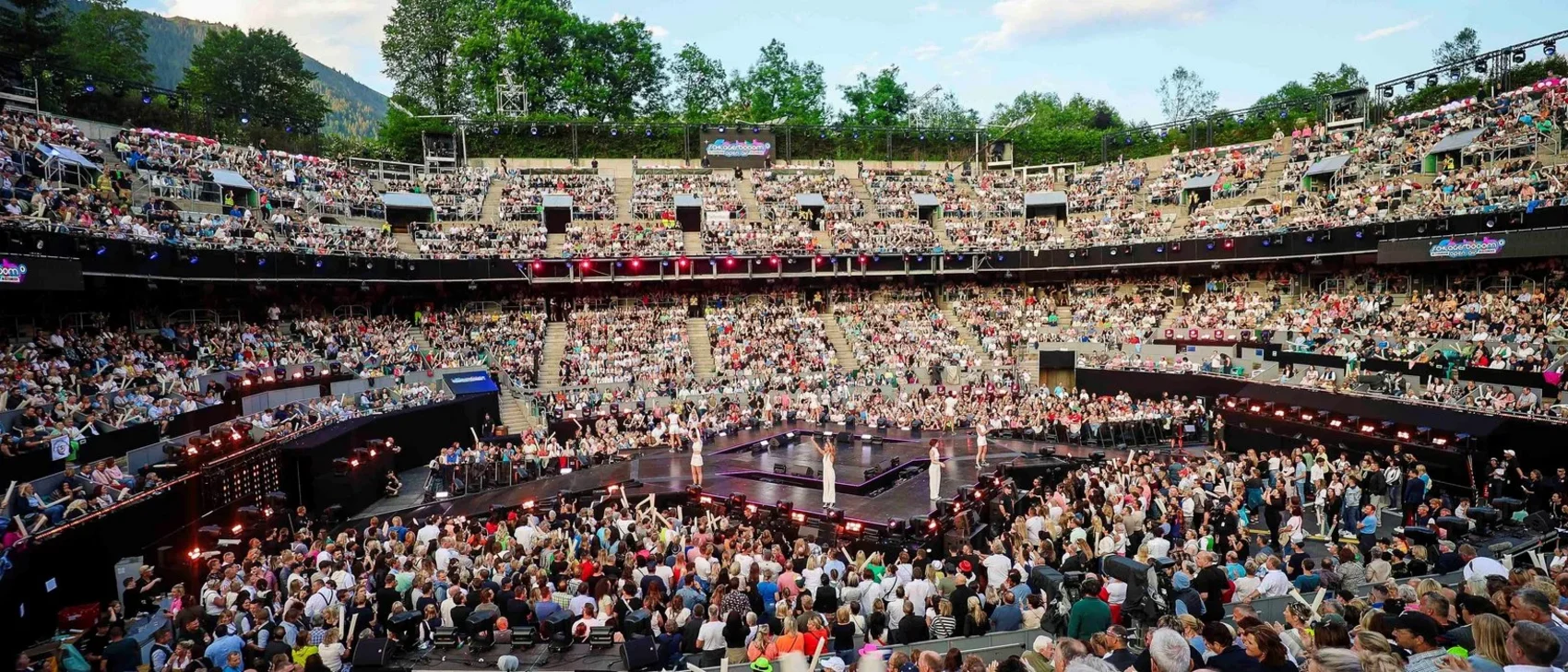 Volles Amphitheater mit Zuschauern bei einer Modenschau im Freien