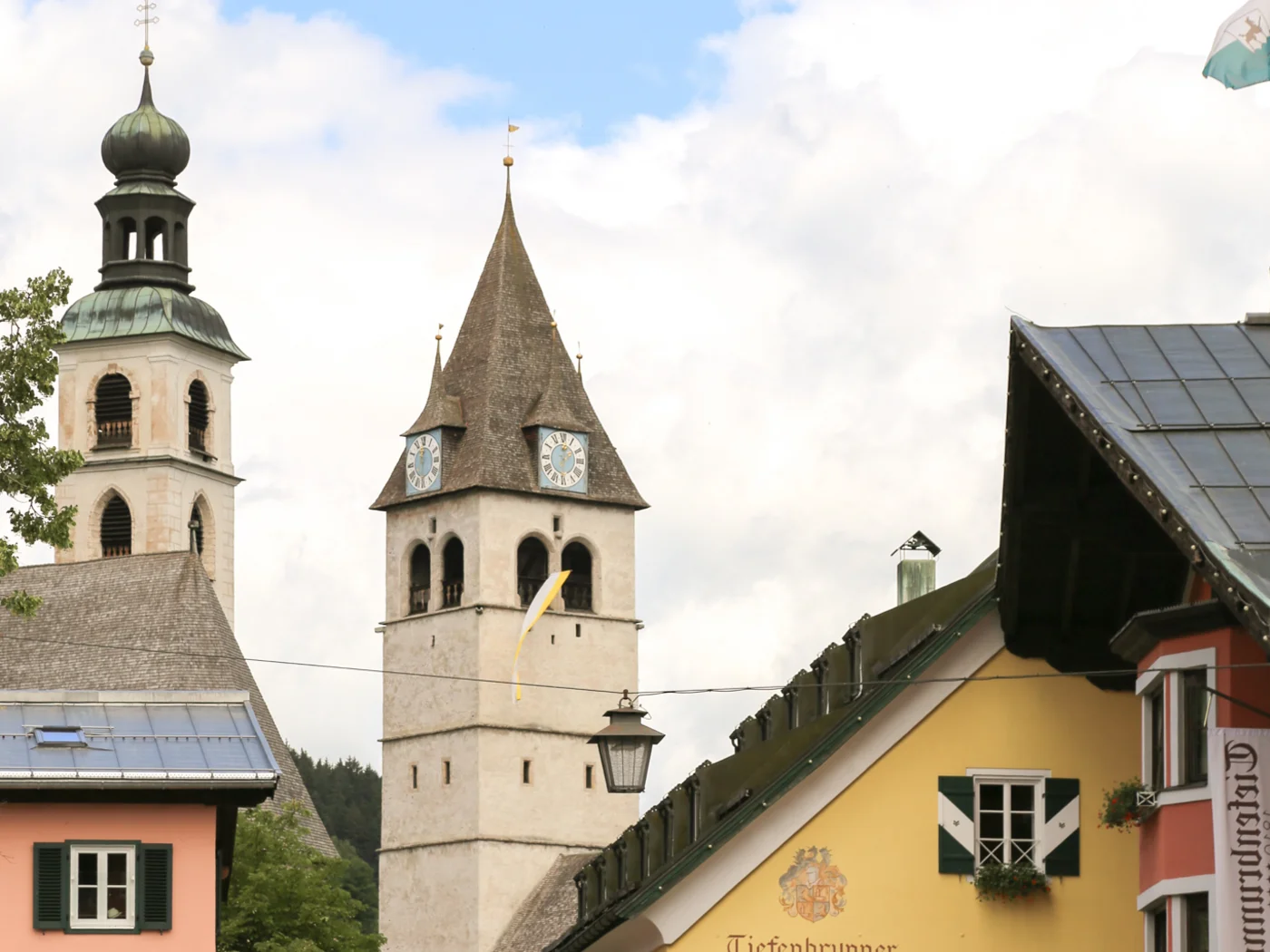 Kitzbühel Historische Kirchtürme und bunte Häuser in einem malerischen Dorf
