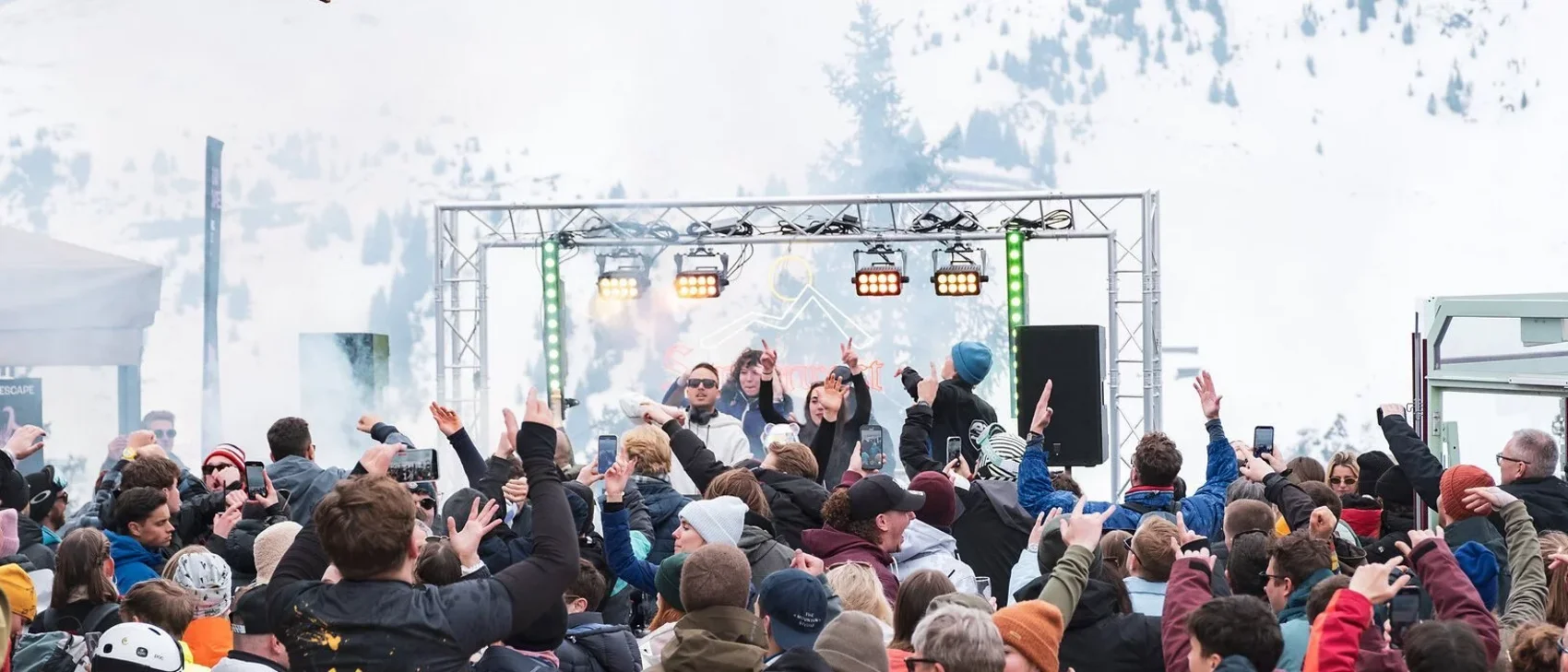 Menschen feiern draußen vor einer Bühne im Schneebergland