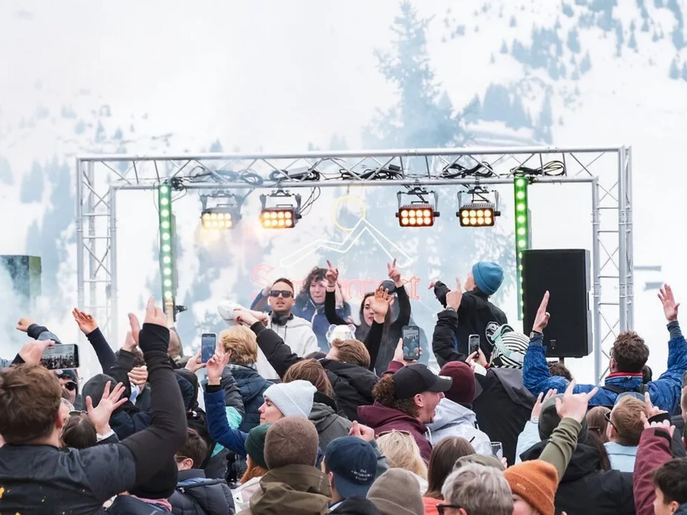 Menschen feiern draußen vor einer Bühne im Schneebergland