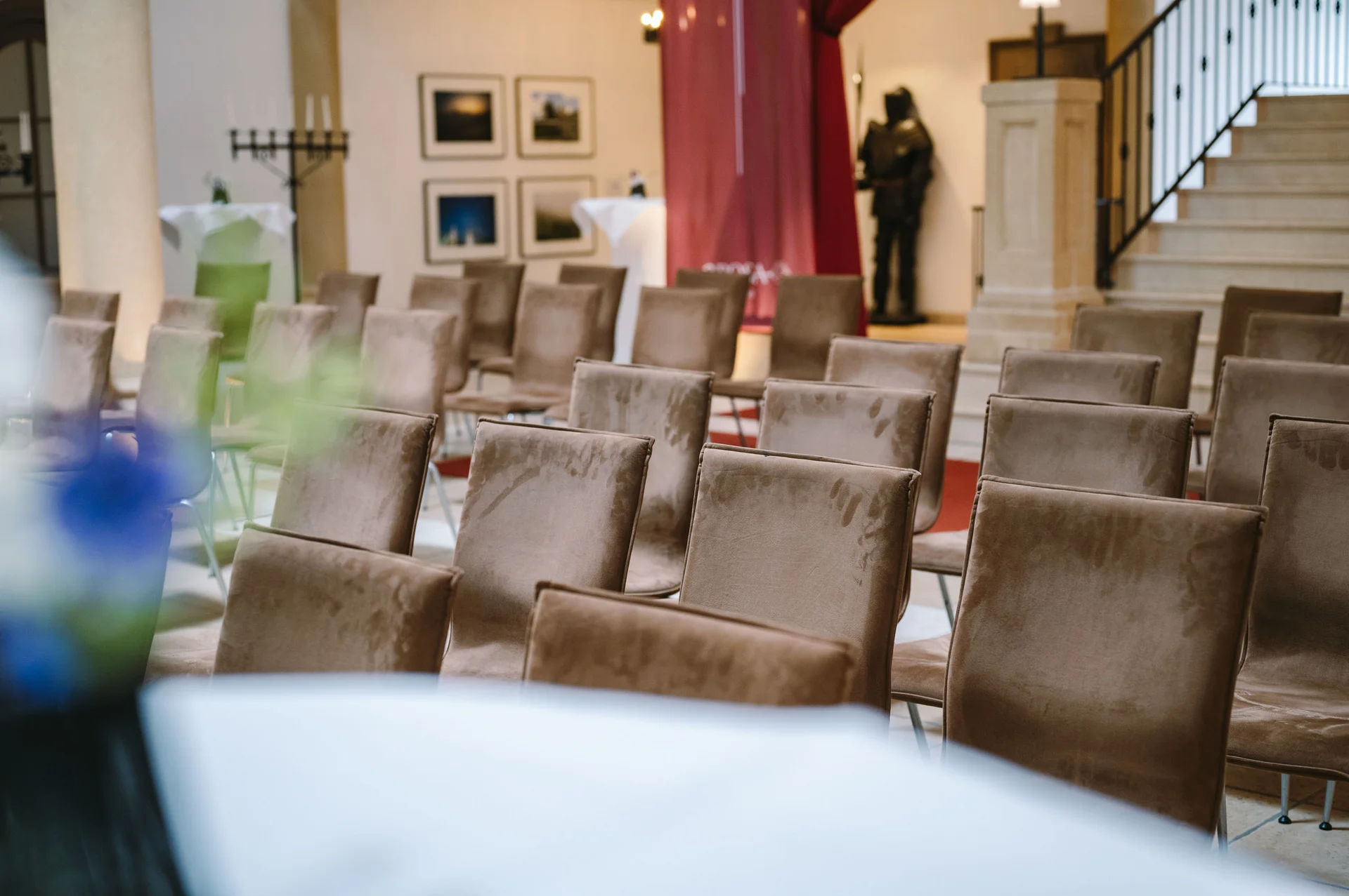 Schlosshotel Kitzbühel: il vostro hotel con sale meeting File di sedie vuote in una sala eventi con un'armatura sullo sfondo.