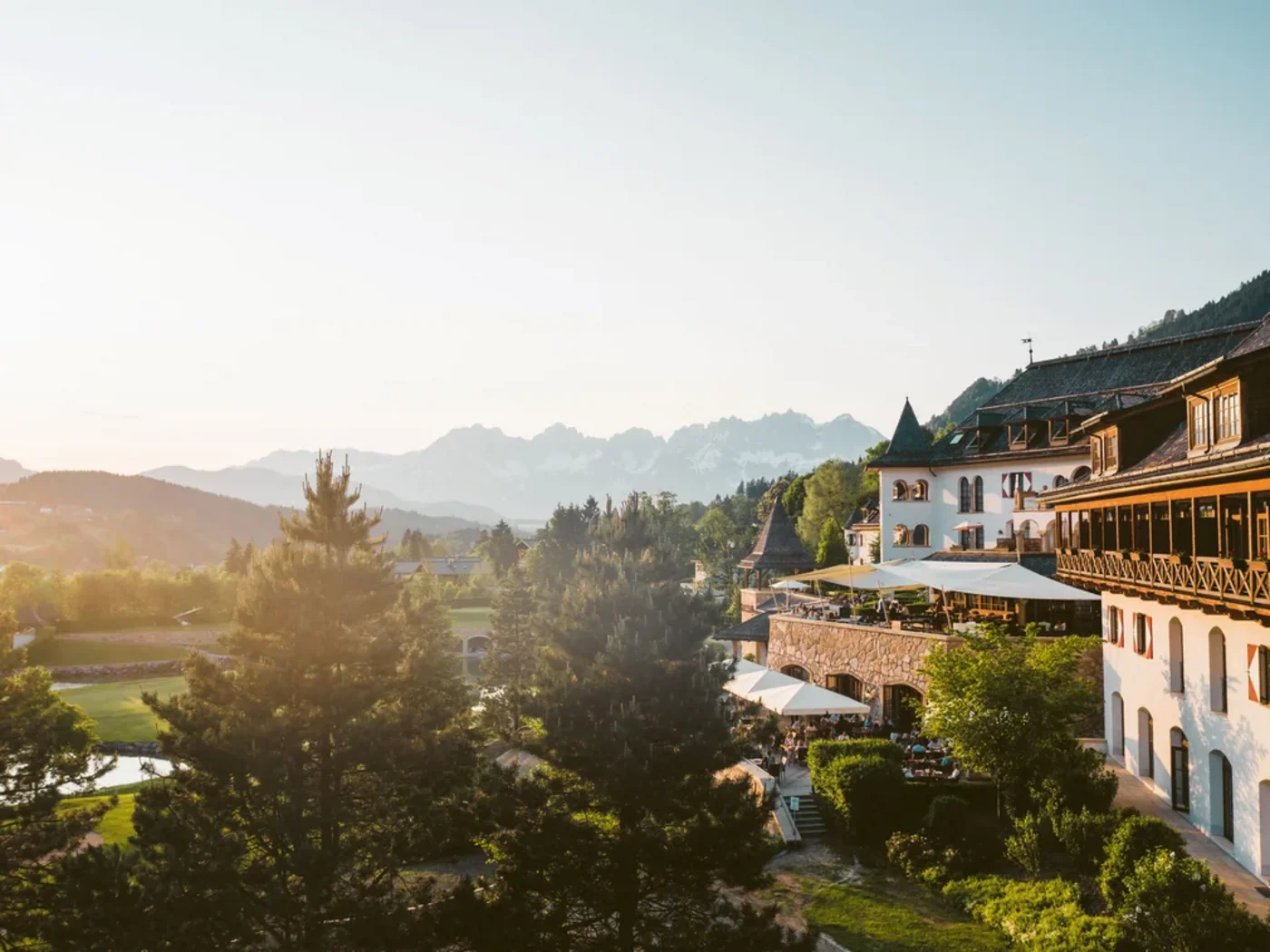 Kitzbühel a ottobre, con un pittoresco resort alpino circondato da paesaggi autunnali, rigogliosa vegetazione e maestose montagne.