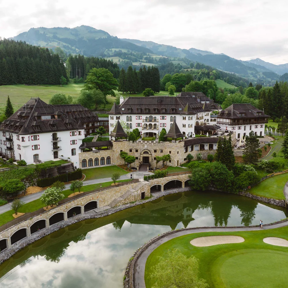 Blog Schlosshotel vor Bergen, umgeben von Wald und Golfplatz mit Teich