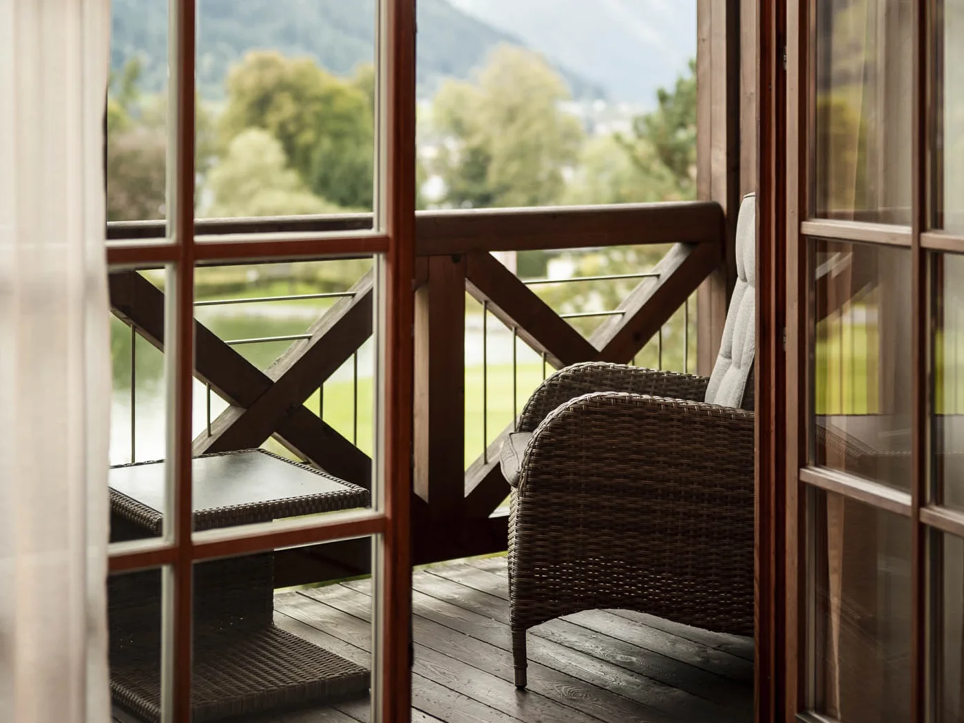 Fenster mit Balkon dahinter und Aussicht über Kitzbühel