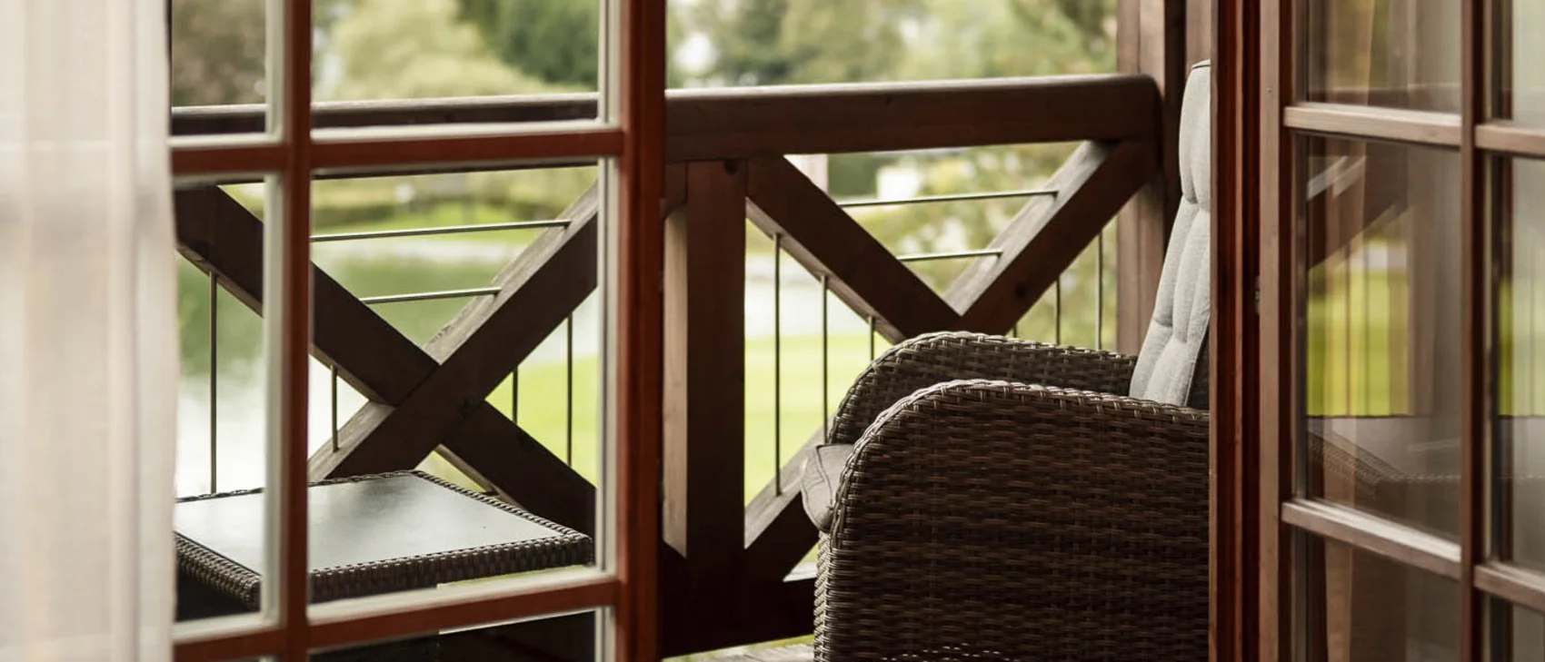 Fenster mit Balkon dahinter und Aussicht über Kitzbühel