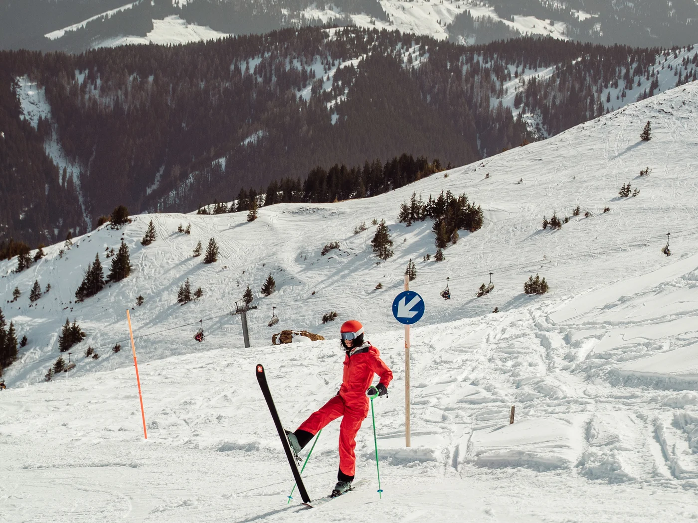 Frau auf Piste im roten Skianzug Frau auf Piste im roten Skianzug