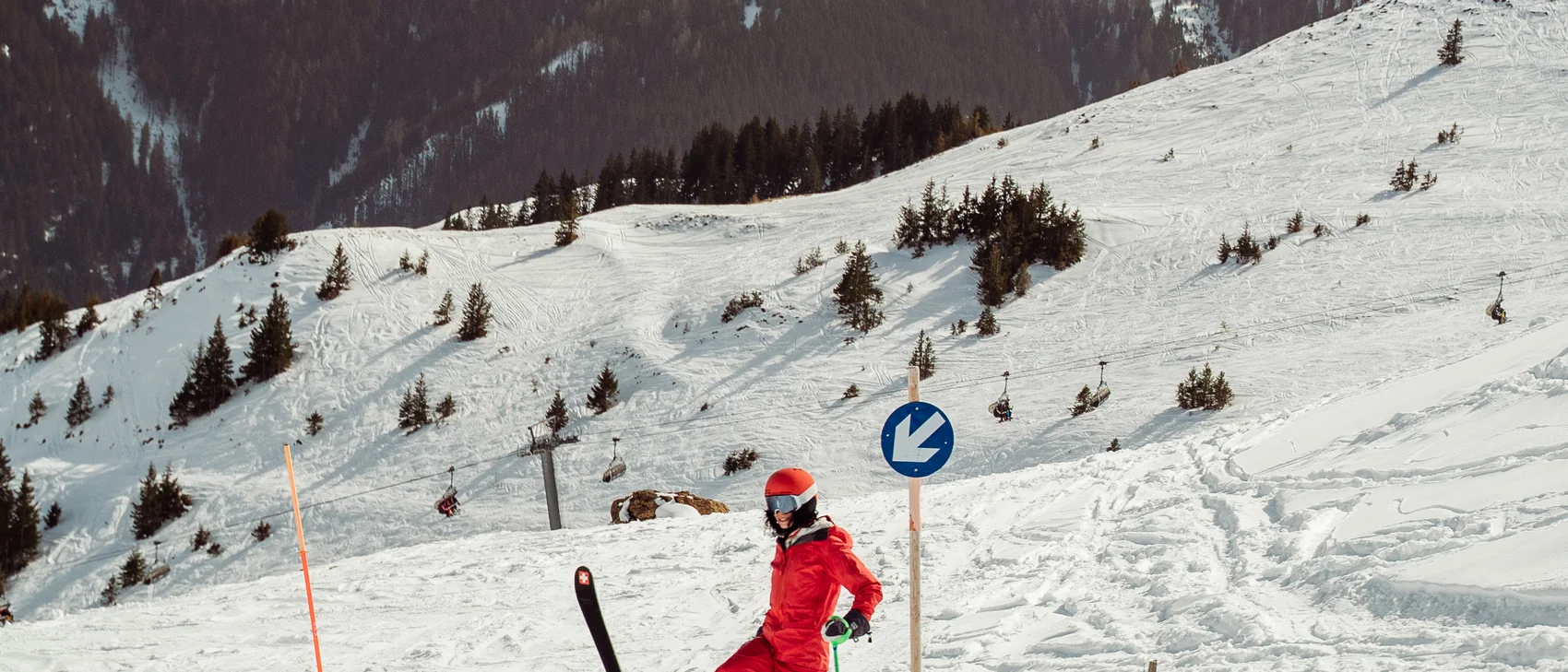 Frau auf Piste im roten Skianzug