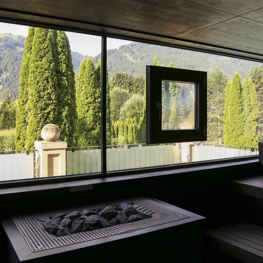 Modern sauna interior with view of mountains and green trees