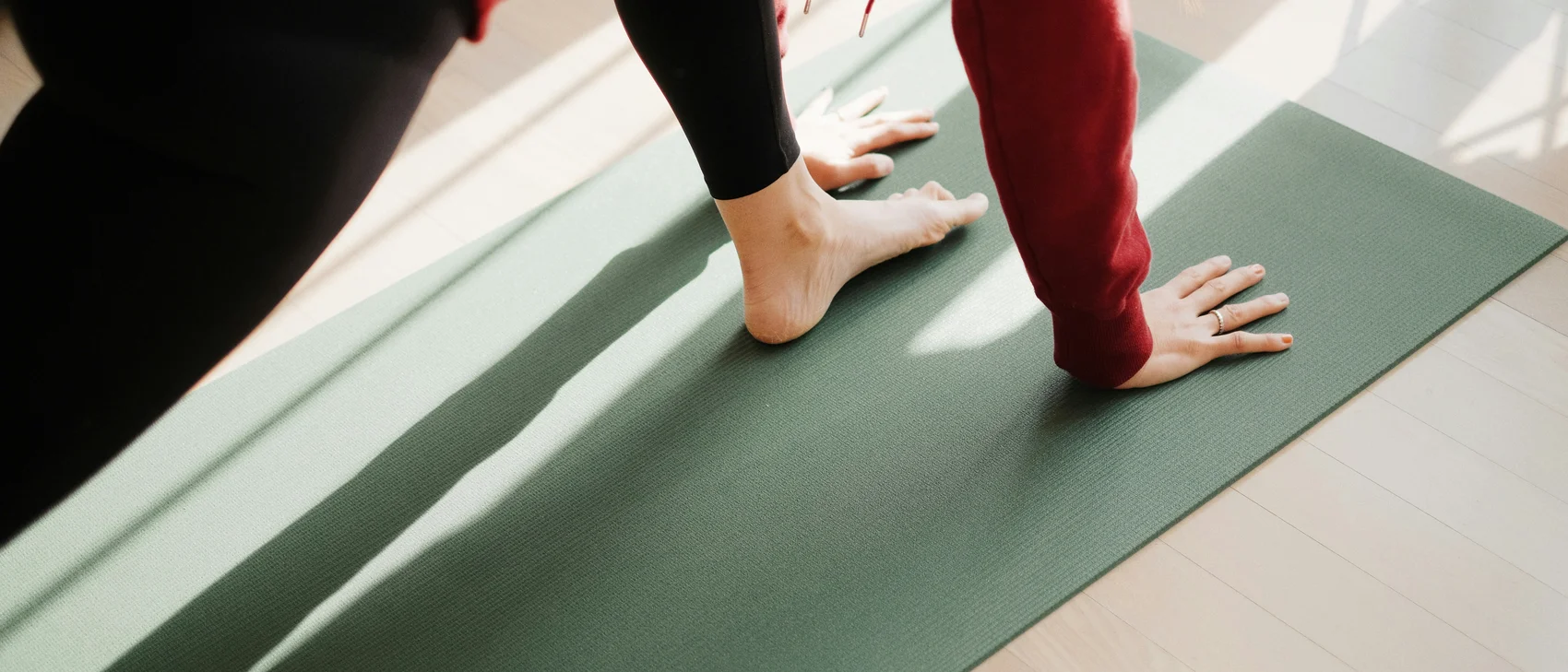Person doing yoga on a mat in the sunlight