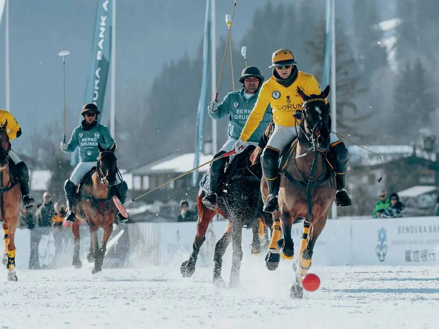 Polo players on horseback playing on a snowy field
