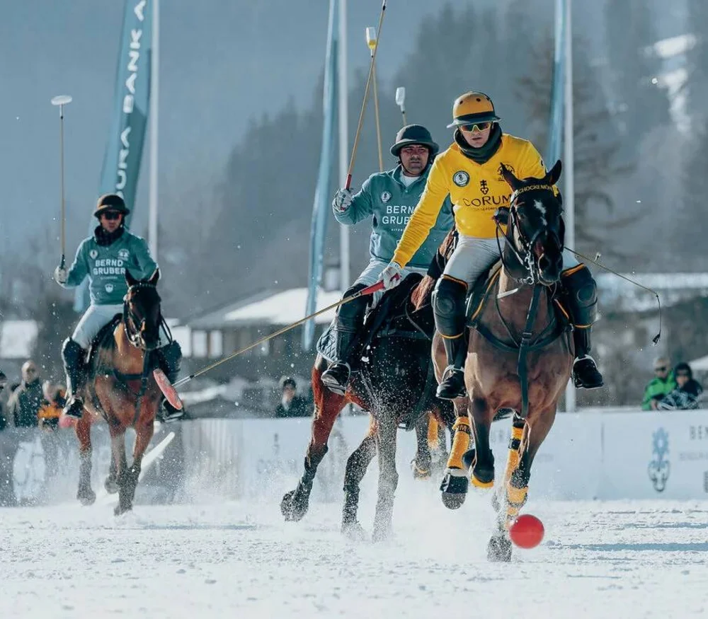 Polo players on horseback playing on a snowy field
