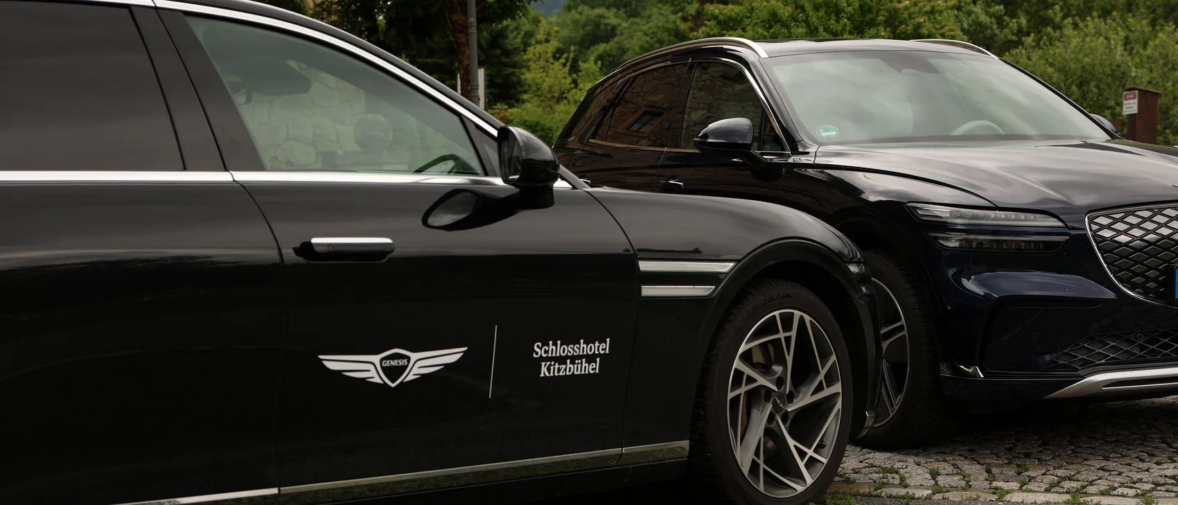 Kooperation von Genesis und Schlosshotel Kitzbühel Autos stehen mit Branding im Bild der Hintergrund ist grüne Natur