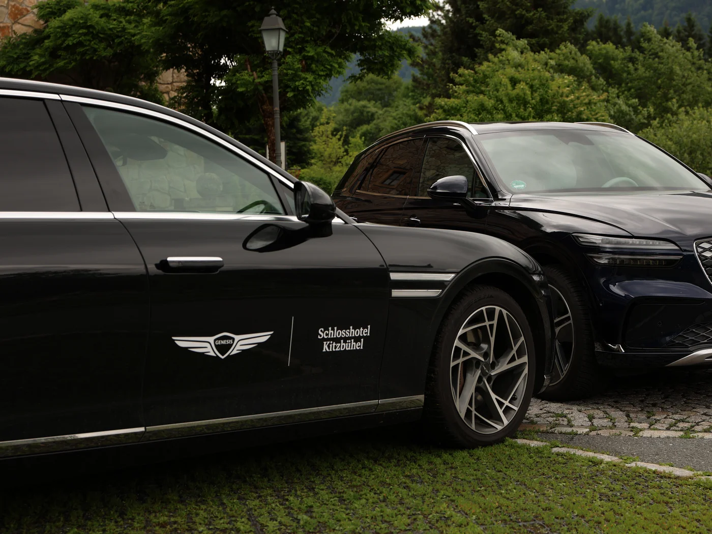 Kooperation von Genesis und Schlosshotel Kitzbühel Autos stehen mit Branding im Bild der Hintergrund ist grüne Natur