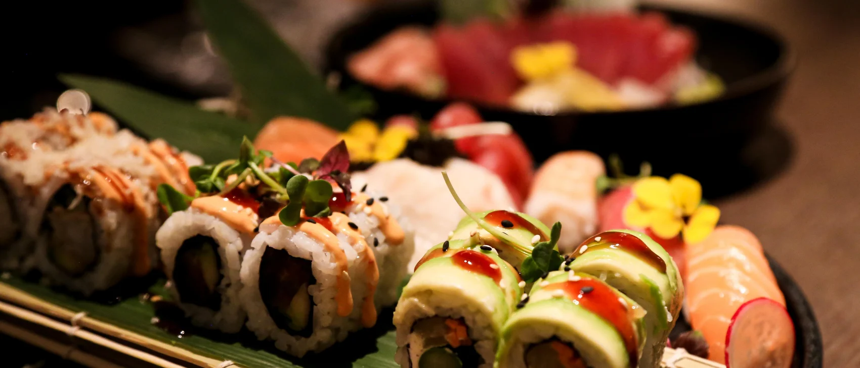 Nahaufnahme von Sushi mit Wasabi und Ingwer auf einem Bambusmatte