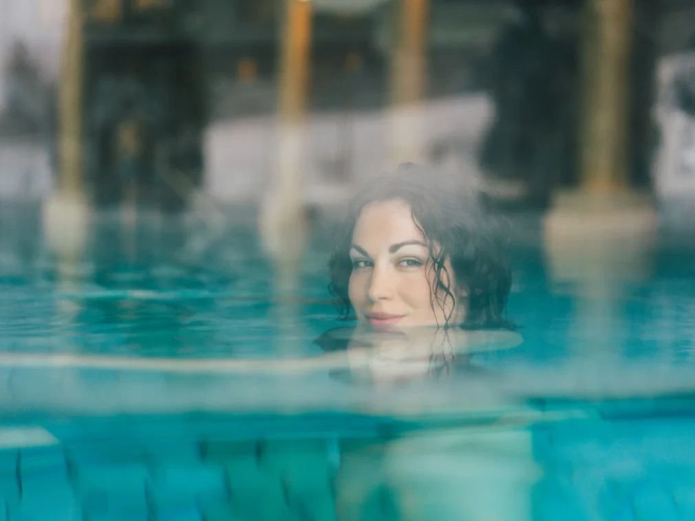 Woman relaxing in a steam bath with water and mist