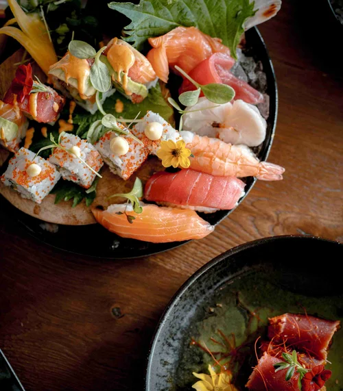 Verschiedene Sushi- und Sashimi-Variationen auf einem Teller angerichtet