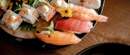 Verschiedene Sushi- und Sashimi-Variationen auf einem Teller angerichtet