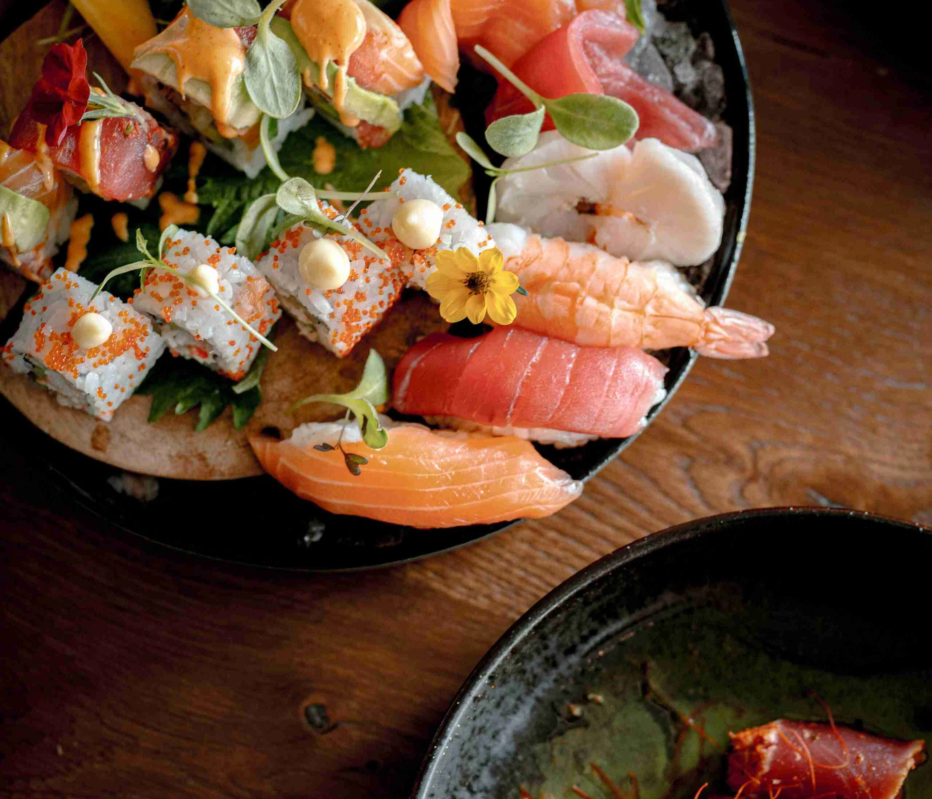 Verschiedene Sushi- und Sashimi-Variationen auf einem Teller angerichtet
