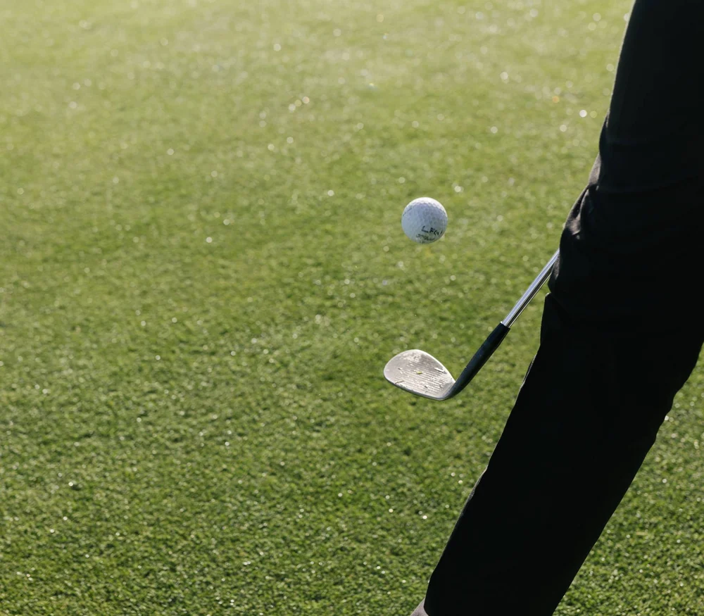 Persona colpisce una palla da golf su un campo da golf verde