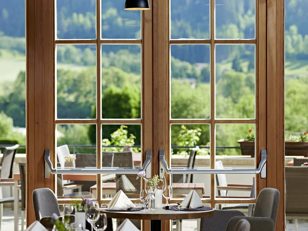 Elegant restaurant with set tables and view of green landscape